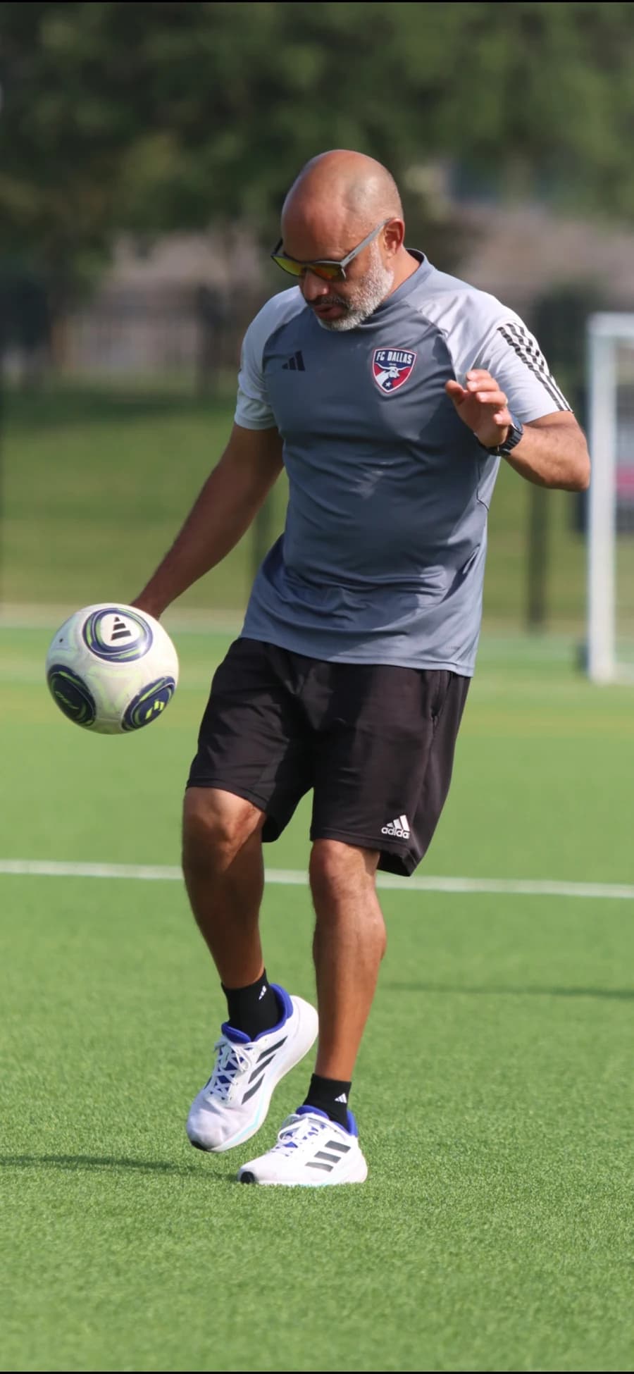 Coach Alberto Carbajal juggling a football on the training pitch in FC Dallas coaching kit